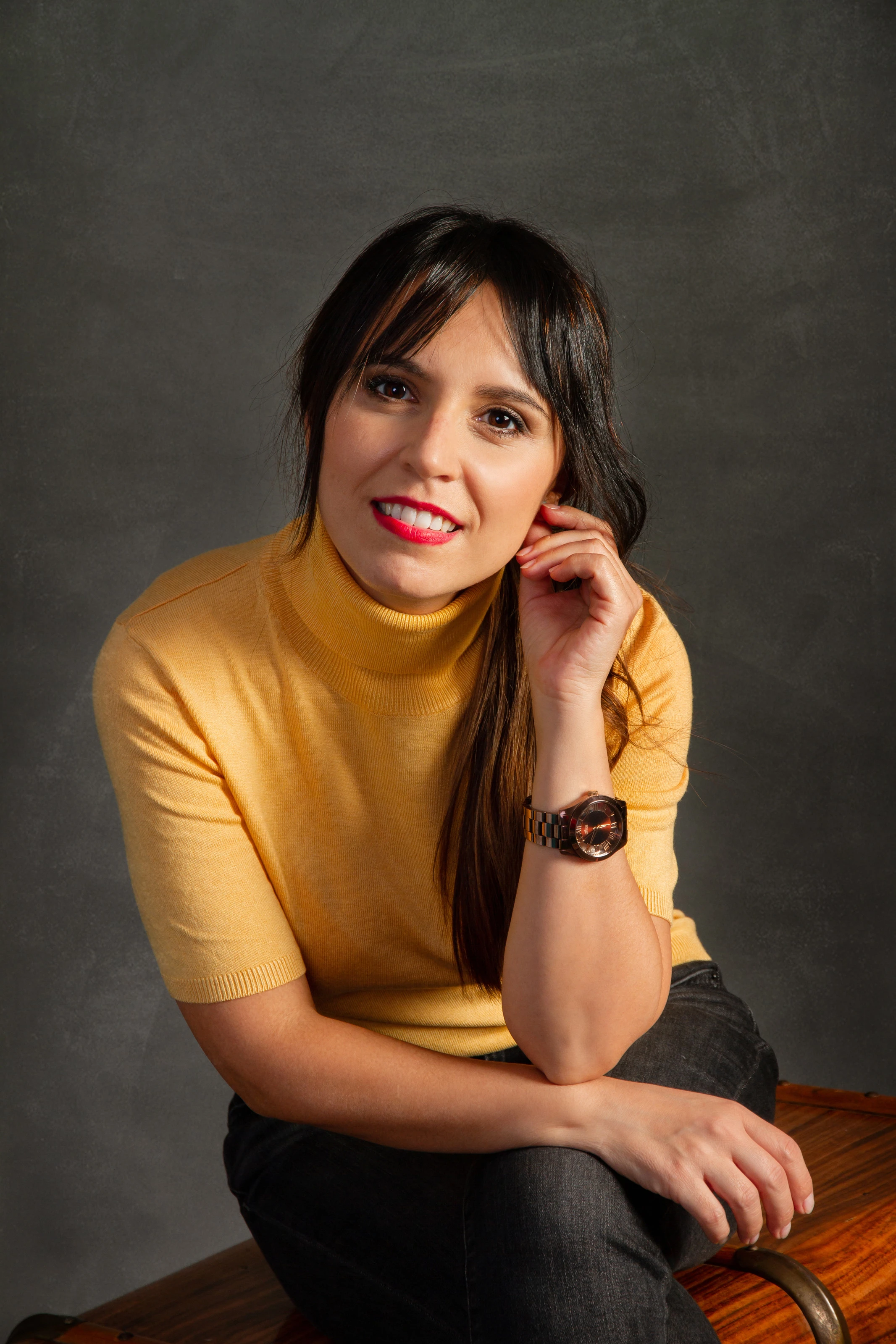 Almudena Lebrero, psicóloga sanitaria, sentada y sonriendo, con un jersey amarillo